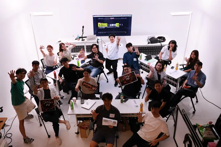 業務前哨戰參與者在討論桌旁舉起 AI 思辨派對手牌合影